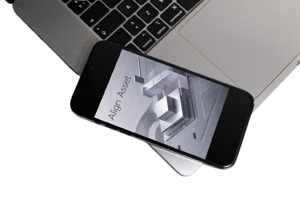 A black smartphone displaying an app interface labeled 'Align Asset' rests diagonally across the open palm of a silver laptop on a white background.